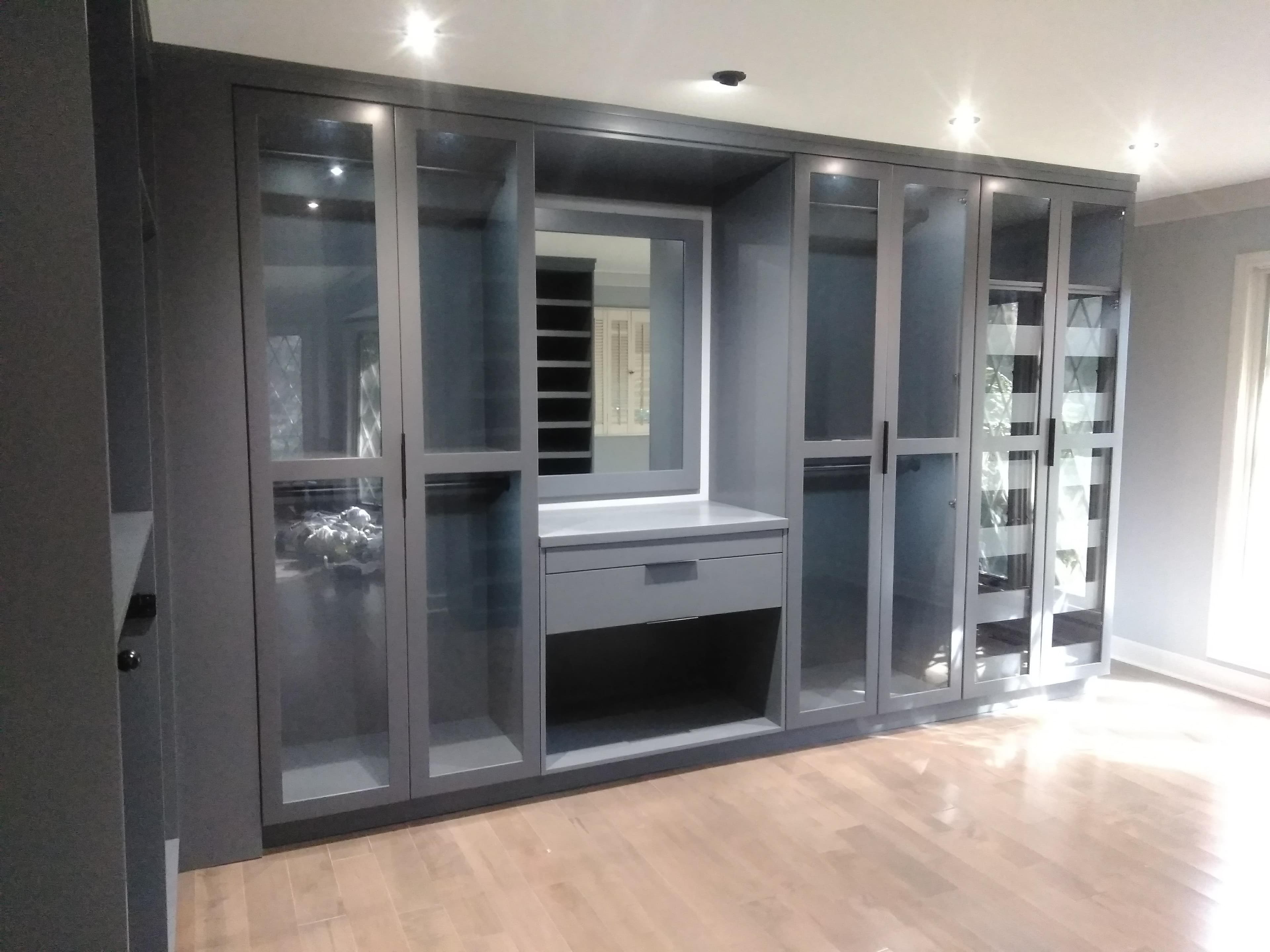 Gray built-in custom closet with glass-front doors built by Hdez Gabinets in Atlanta