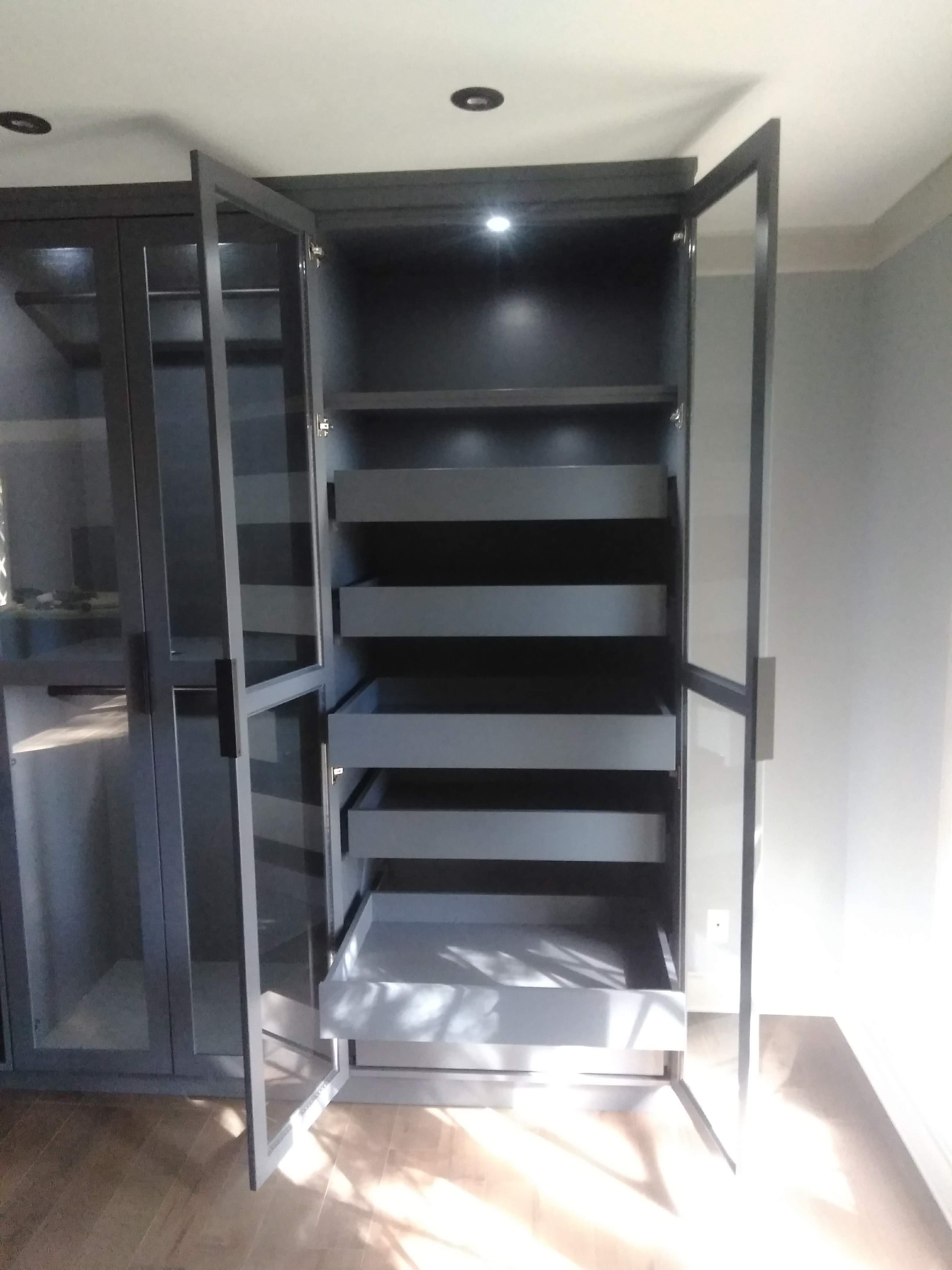 Custom wardrobe cabinet with glass doors and five full-extension pull-out drawers built by Hdez Gabinets